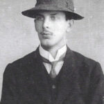 Man in Edwardian attire and a slightly crumpled hat.