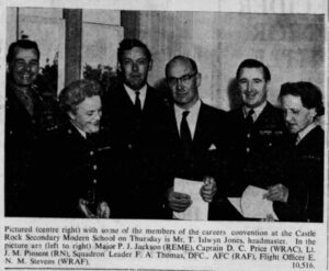 Newspaper photo of a group of people, mostly in uniform.
