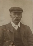 Yellowed photograph of a man in a flat cap.