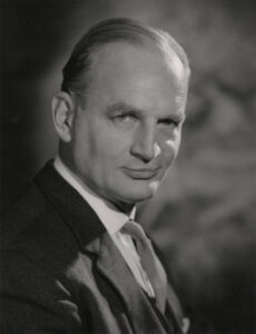 Smirking man wearing a suit.