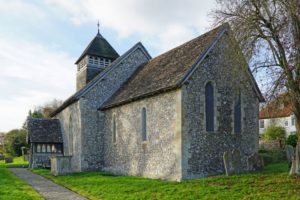 A simple grey stone church with a low steeple