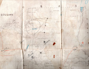 A battered map of Sudan marked with notes and pencil scratches showing patrol movements.