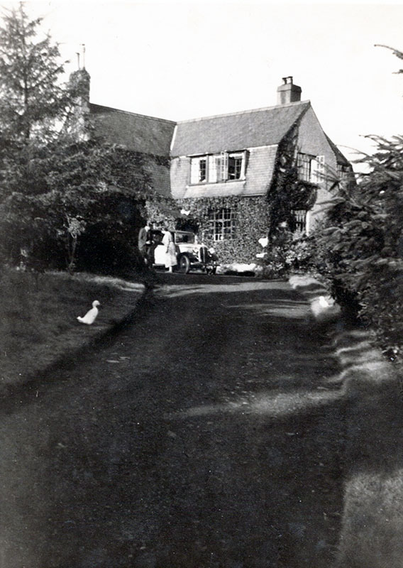A blacck and white photograph of the drive up to Higherfield, with the building behind.