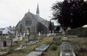 An old English church and graveyard on an overcast day.