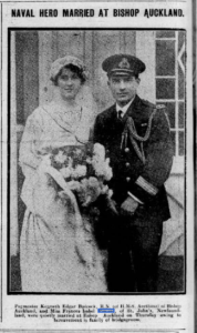 A wedding portrait of a man in uniform and a woman in a white dress.