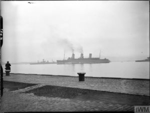 A ship with three stacks photographed in the distance.