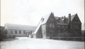 A hazy black and white photograph of a stone building with an unusual slanted roof.