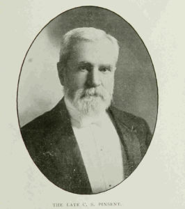 An older man with a white beard in a suit with a white bow tie.