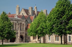 A colourful modern photo of an ornate stone building with red roofs 