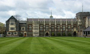 Huge, ornate stone building with an immaculate cut lawn in front.