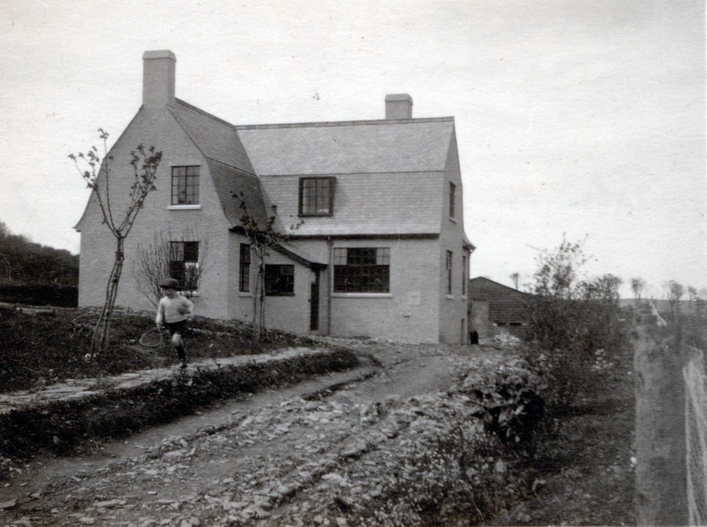 Robin, a young boy, runs along the low wall outside his home at Higherfield.