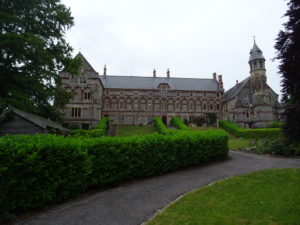 A modern photograph of large ornate building made of limestone and sandstone.