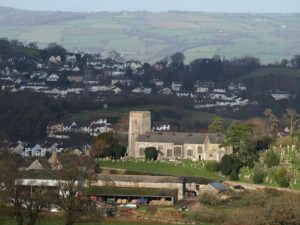 Photograph of a stone church nestled into the broader countryside.