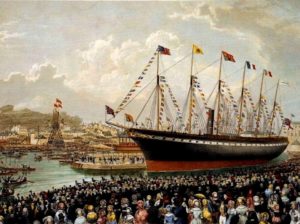 Painting of a black sailship with flags flying from its many masts. Countless people throng the docks in front of it.