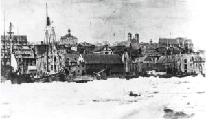 A faded black and white photograph of the wharves at St. John's, Newfoundland, seemingly locked in with ice and snow.