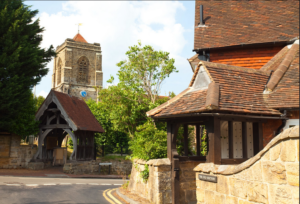 Bright modern photograph of a red stone church and other buildings.